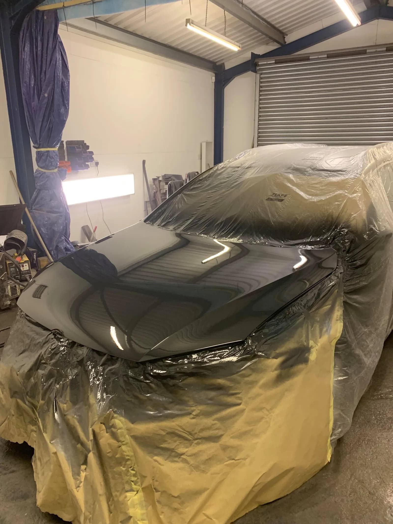 A dark bonnet masked up under the booth lights